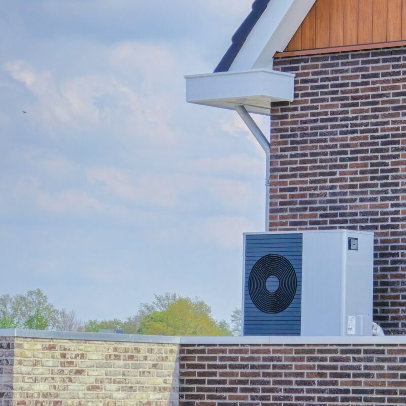 air source heat pump unit installed outdoors at a modern home with bricks in the Netherlands