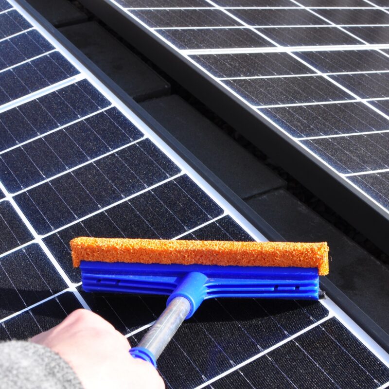 Cleaning solar panels with a wiper